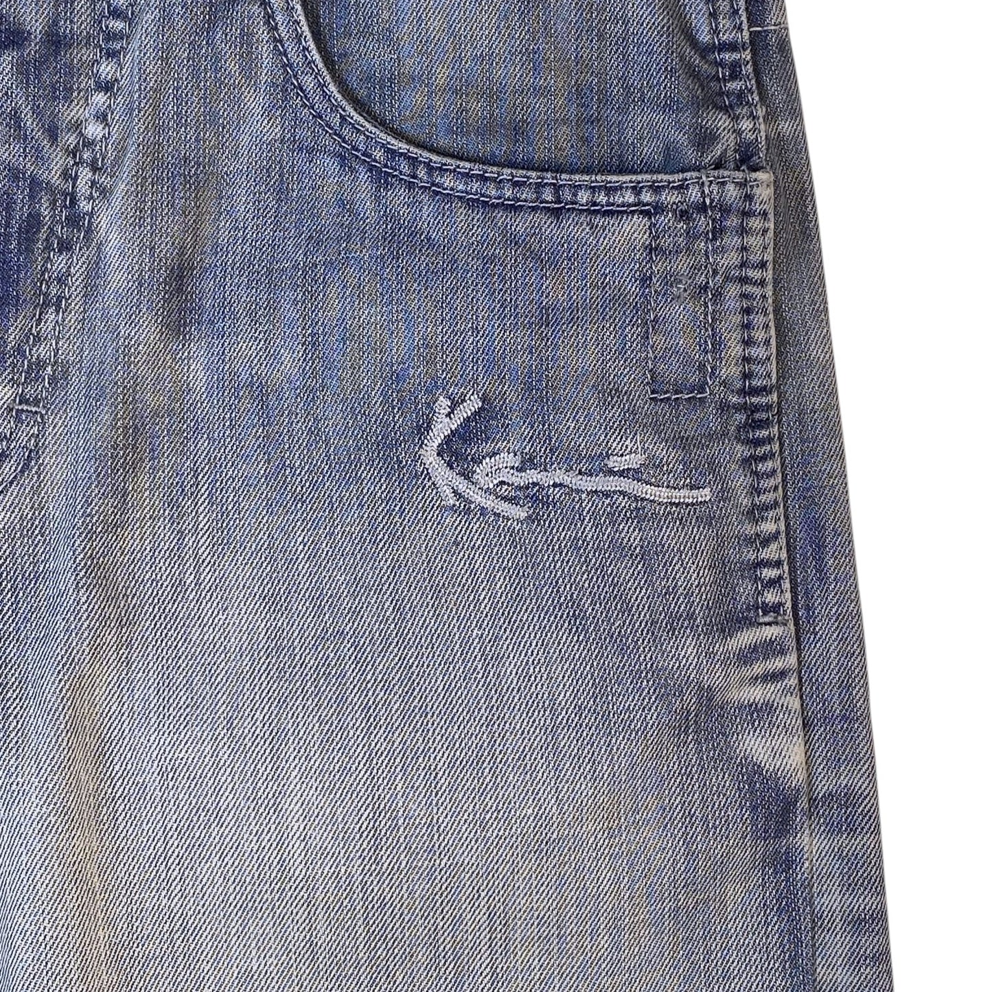 Close-up of a pair of blue denim jeans showing the back pocket and a small white embroidered logo on the upper right side.