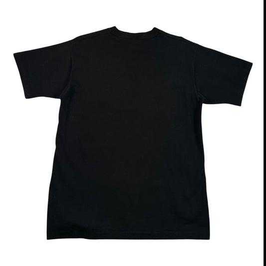 A black short-sleeve crewneck t-shirt laid flat on a white surface covered with clear plastic wrap.