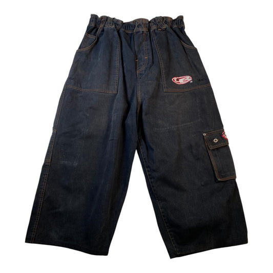 Dark indigo denim work pants with an elastic waistband, large front utility pockets, and a small red and white logo patch on the upper right thigh, shown against a plain white background.