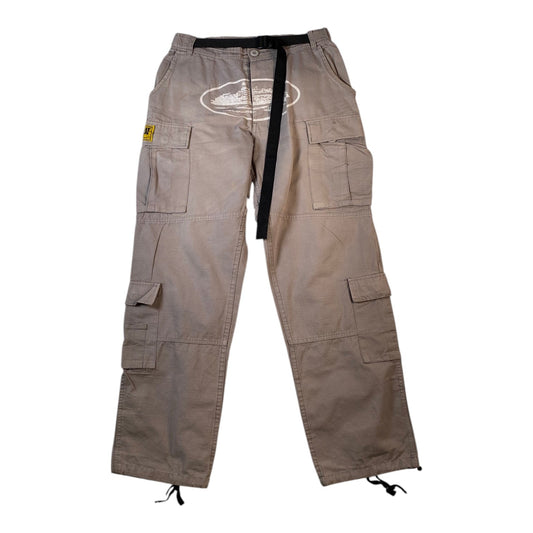 A pair of beige cargo pants with a black drawstring waist, multiple utility pockets, and a white graphic print on the upper right thigh, shown against a plain white background.