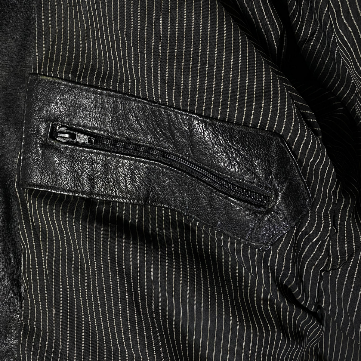 Digg It Thrift & Vintage black leather field parka interior featuring a zippered pocket and pinstripe lining