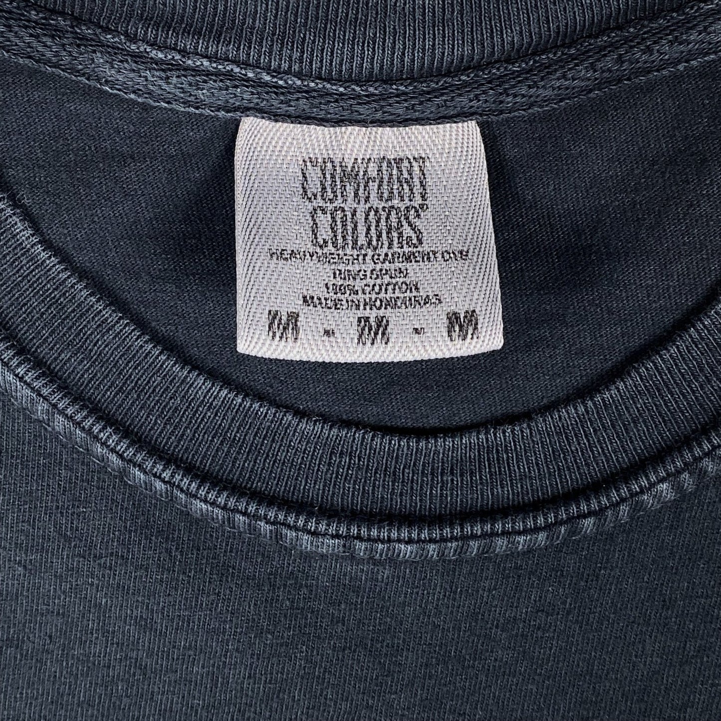 Digg It Thrift & Vintage Comfort Colors tag on a black garment-dyed cotton t-shirt, size medium.