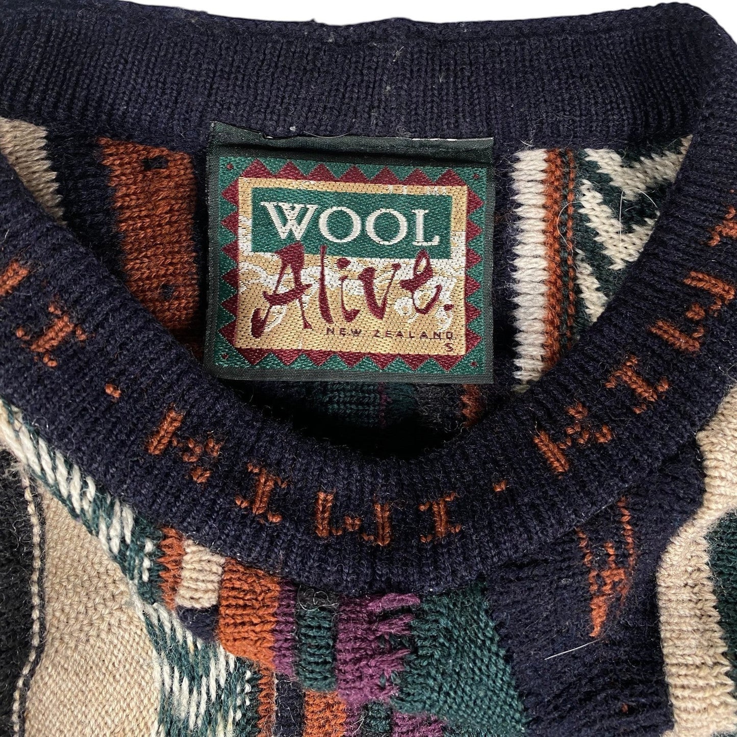 Digg It Thrift & Vintage Wool Alive New Zealand textured knit crewneck sweater with a patterned collar label