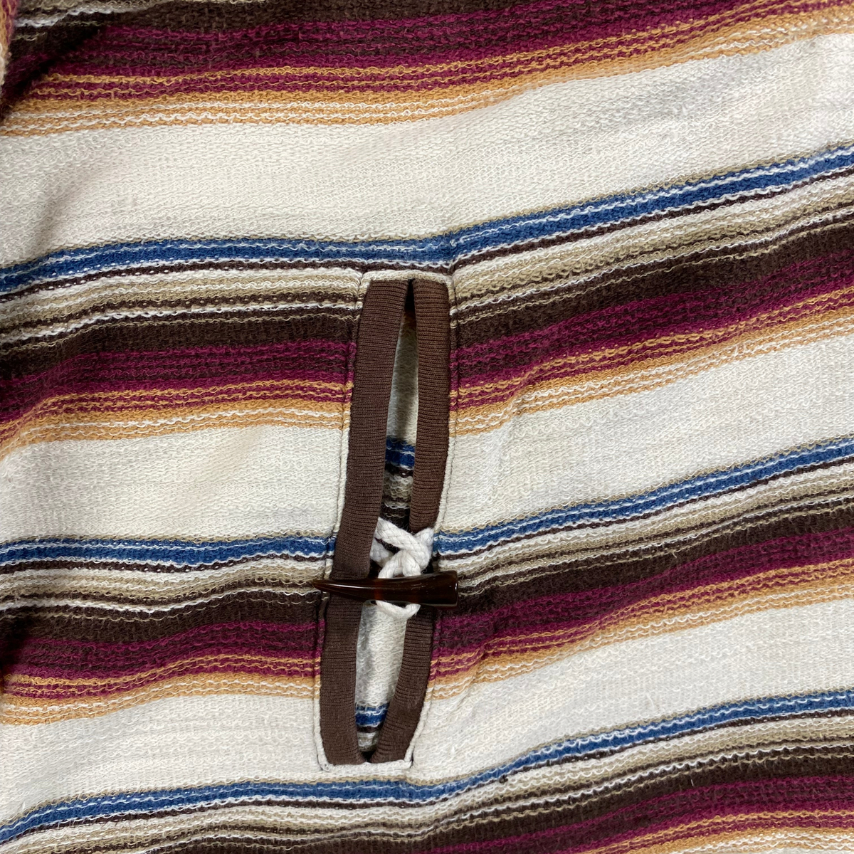Digg It Thrift & Vintage Stüssy vintage Baja hoodie featuring multi-colored stripes and a wooden bead toggle closure.