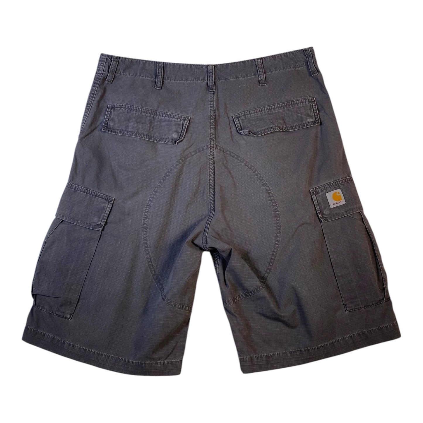 A pair of dark gray Carhartt cargo shorts shown from the back, featuring a central seam, two back welt pockets, and side cargo pockets with the signature Carhartt logo patch.