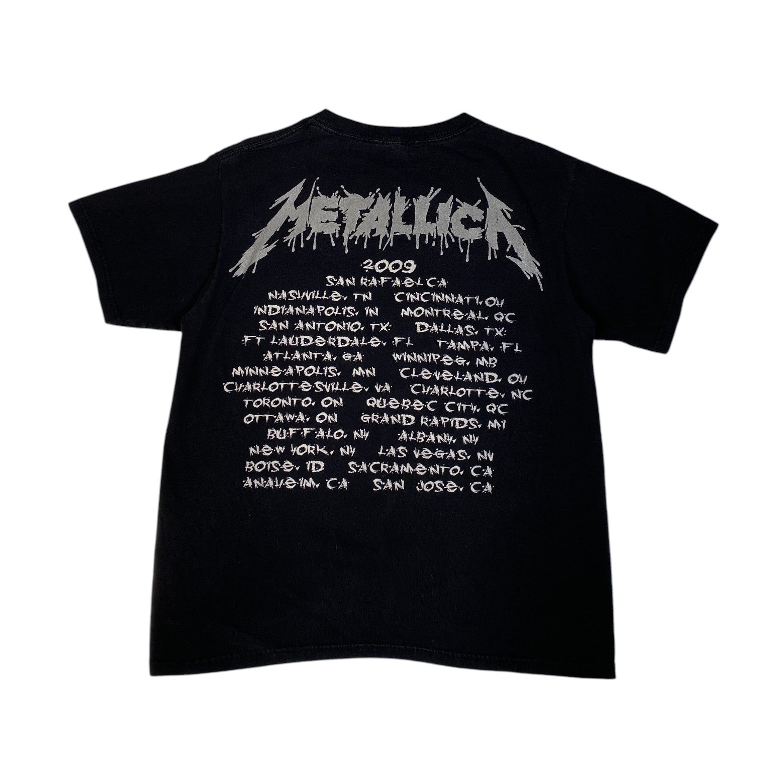 A black short-sleeve Metallica t-shirt showing the back side, which features a large white 'Metallica' logo above a white printed concert tour schedule from San Rafael, 2009.