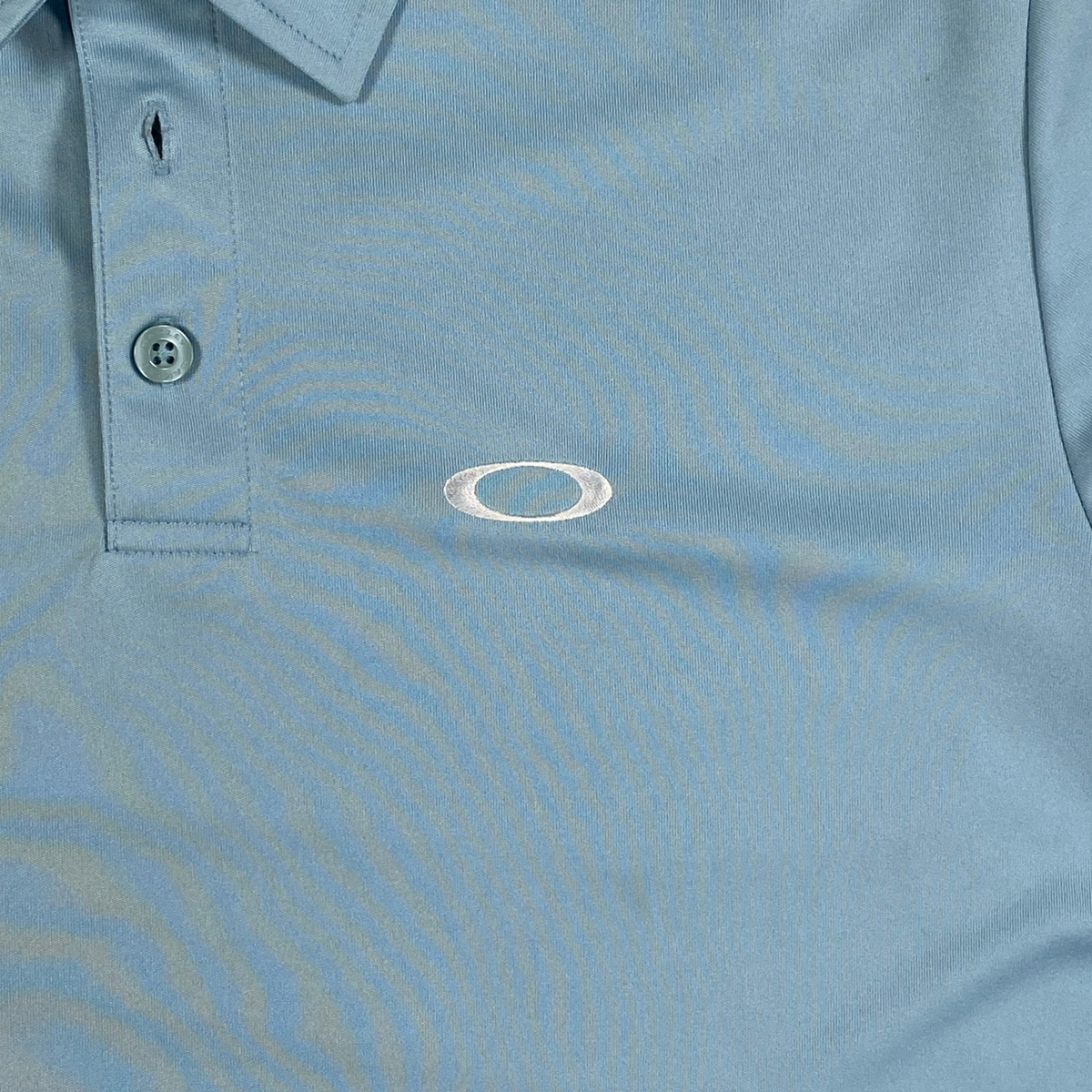 Digg It Thrift & Vintage light blue Oakley athletic golf polo shirt with a classic collar and button placket.