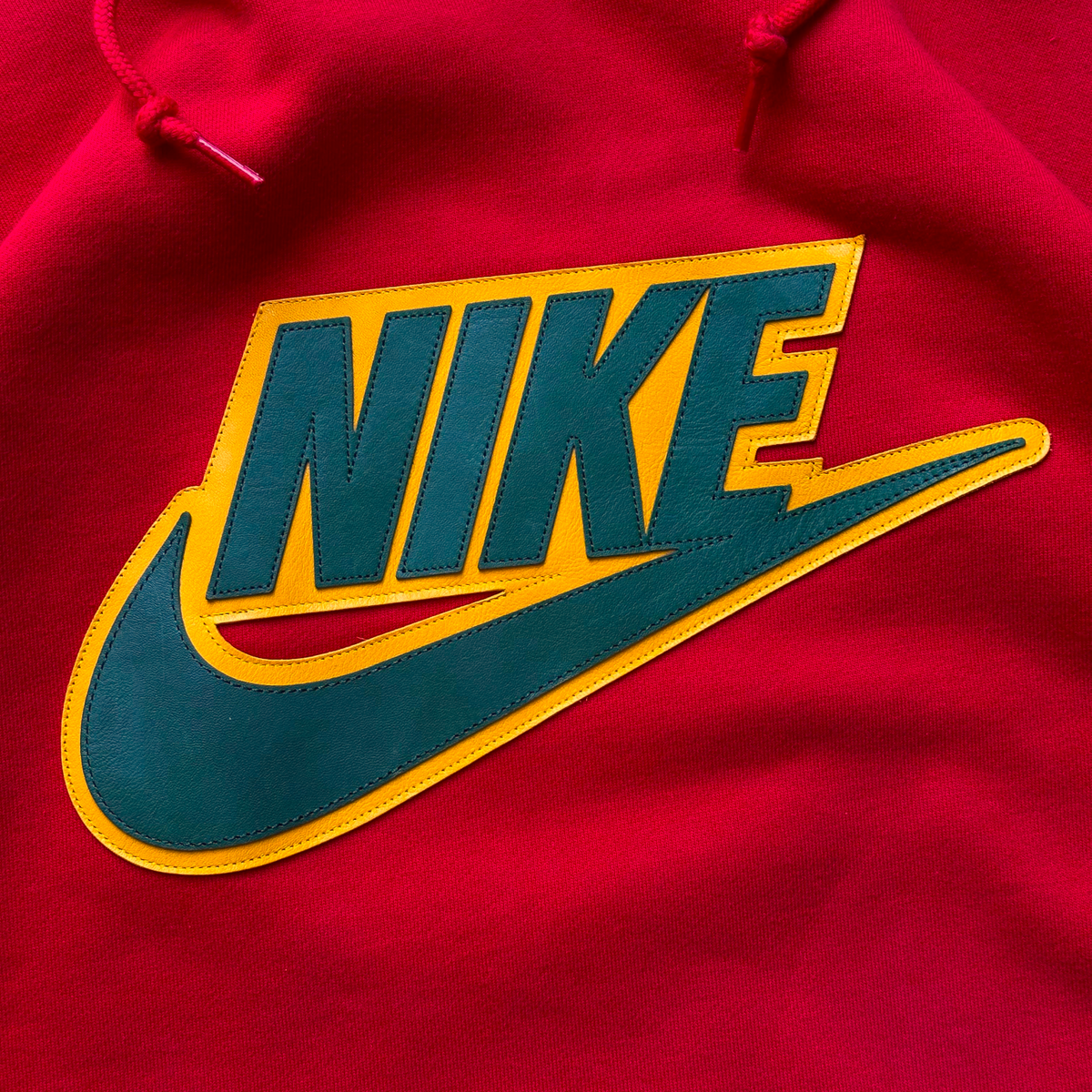 Digg It Thrift & Vintage Nike x Supreme red hoodie featuring a large leather Nike logo applique on the chest