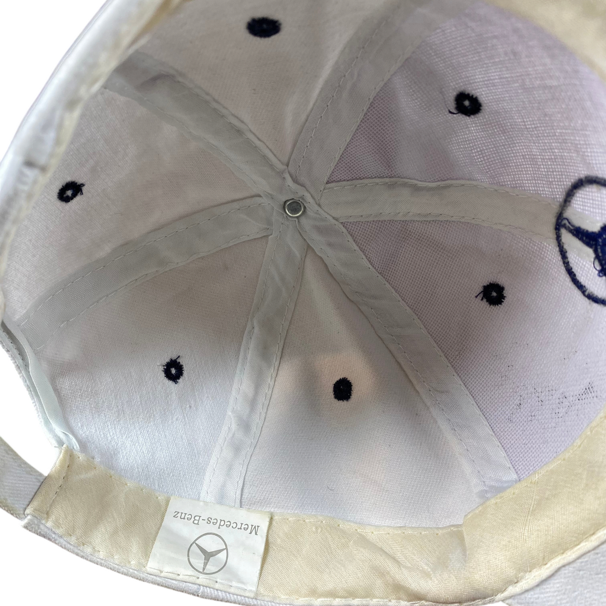 Interior view of a white Digg It Thrift & Vintage Mercedes-Benz baseball cap showing the brand label and stitching.