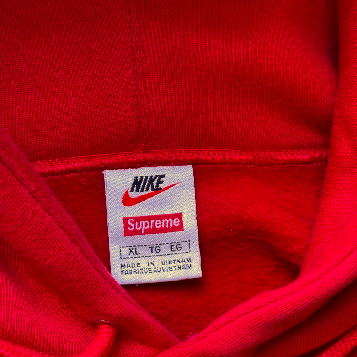 Digg It Thrift & Vintage Nike x Supreme red hoodie interior neck label showing size XL and branding details