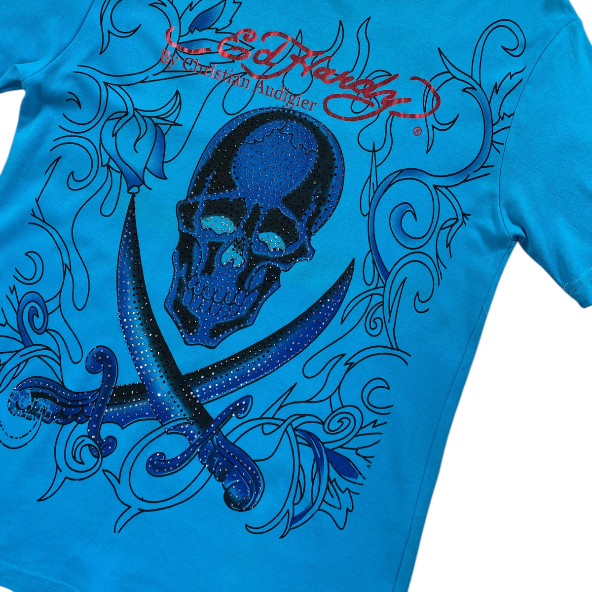 Digg It Thrift & Vintage turquoise Ed Hardy t-shirt featuring a rhinestone skull and swords graphic design.