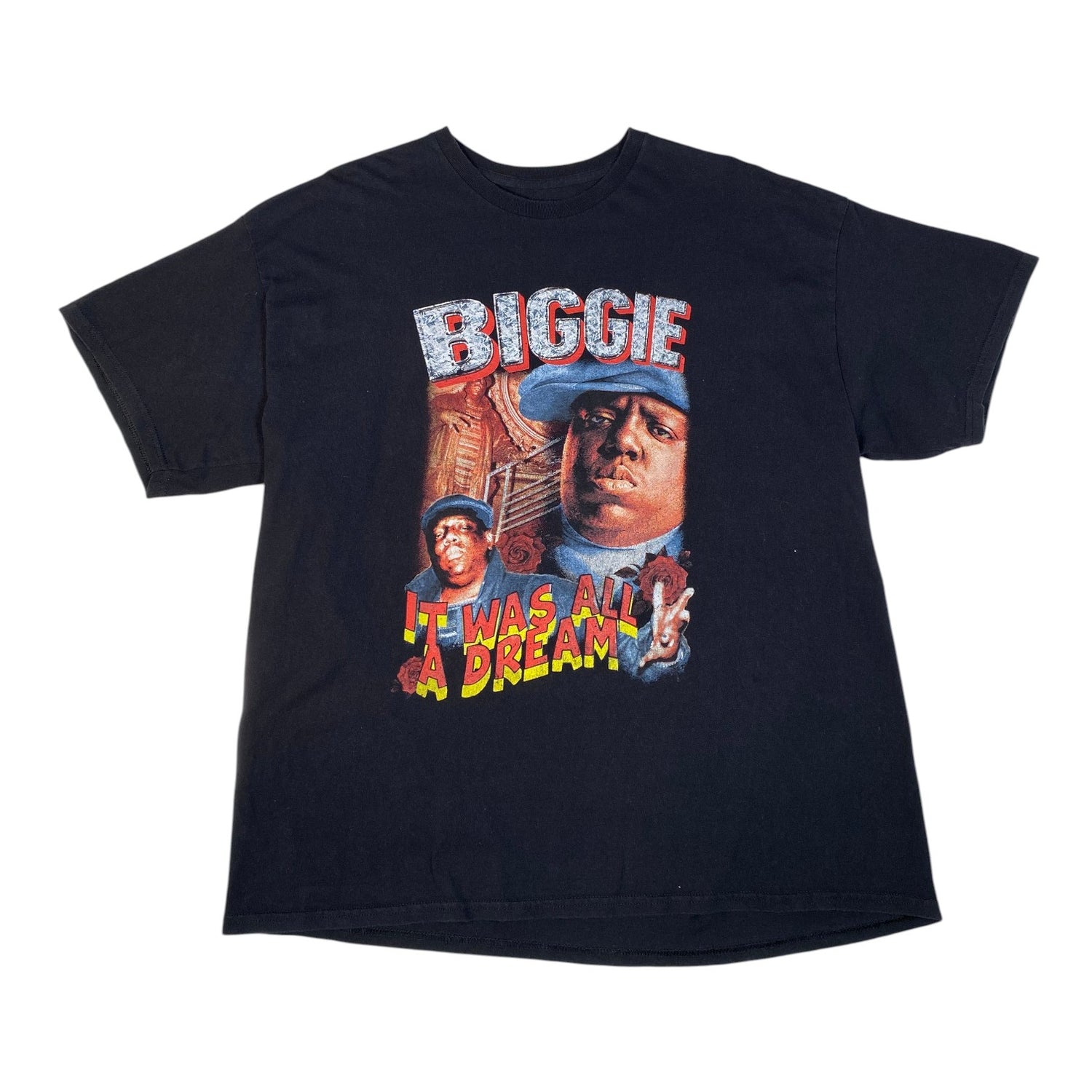 A black short-sleeve graphic t-shirt featuring a large front print of a portrait of Biggie Smalls with the text 'BIGGIE' and 'IT WAS ALL A DREAM!' in red, yellow, and blue.
