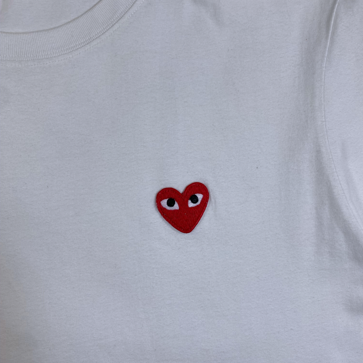 Digg It Thrift & Vintage white t-shirt featuring a small red embroidered heart with eyes on the chest