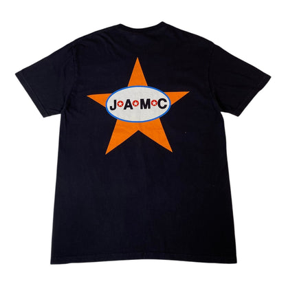 A black short-sleeve t-shirt with a large graphic on the back featuring an orange star and a white oval logo with the text 'JO'A'MOC' in black and a small red cross.