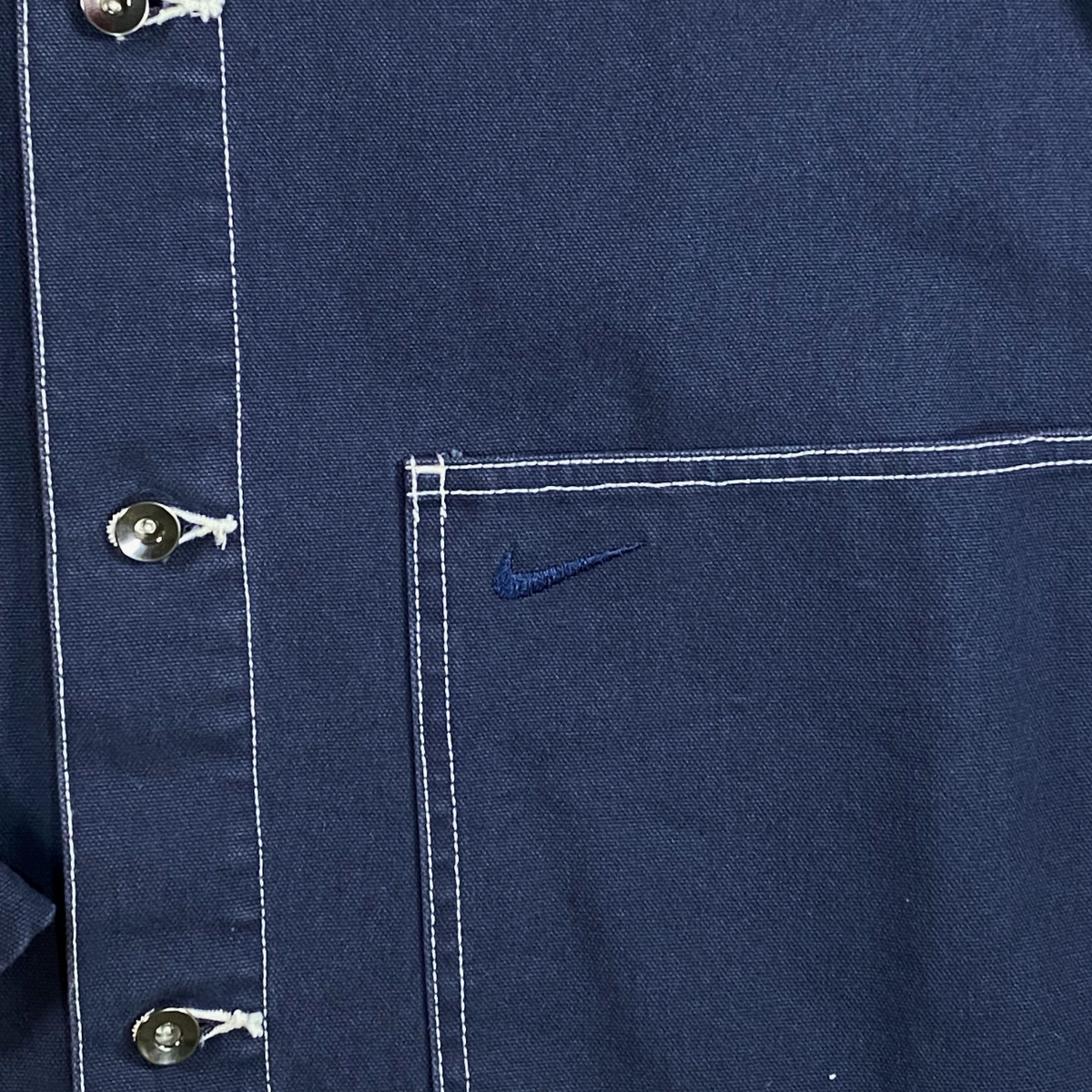 Digg It Thrift & Vintage navy canvas chore jacket with white contrast stitching and embroidered Nike swoosh logo