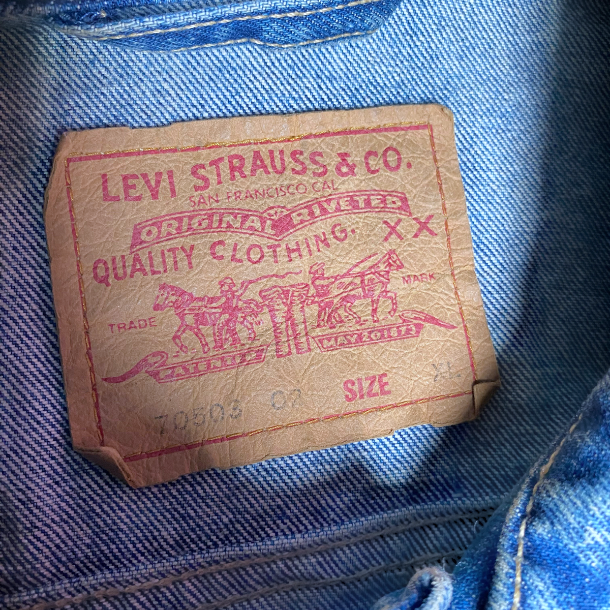Digg It Thrift & Vintage Levi's denim trucker jacket leather brand patch with red logo text on blue denim fabric