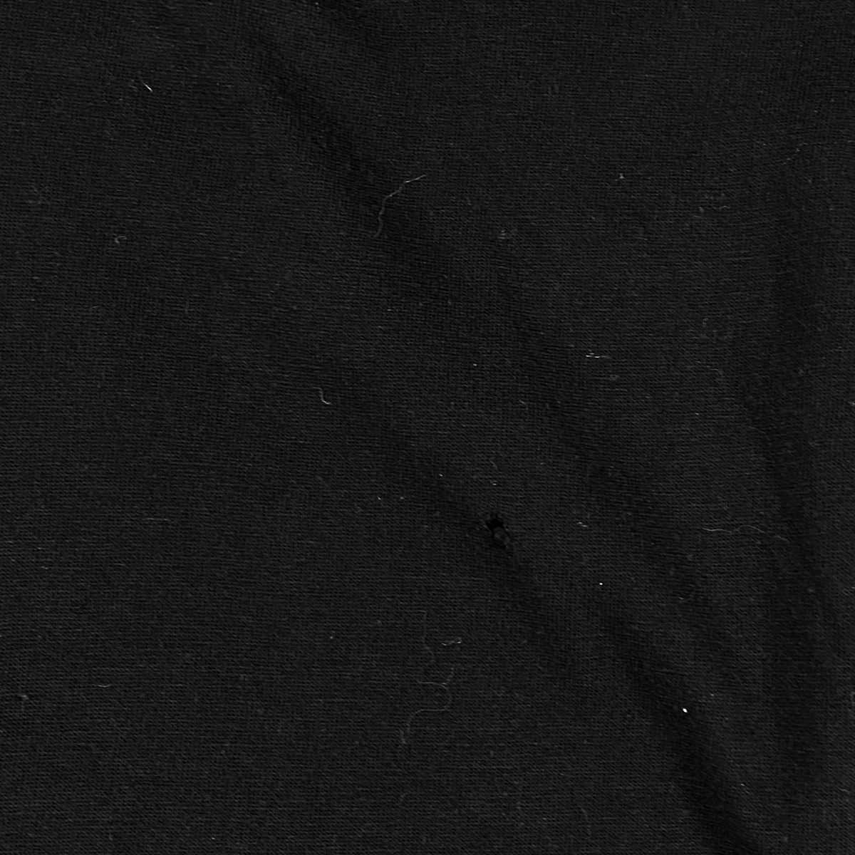 Digg It Thrift & Vintage black cotton fabric texture with a small hole detail from a vintage Asterix & Obelix shirt