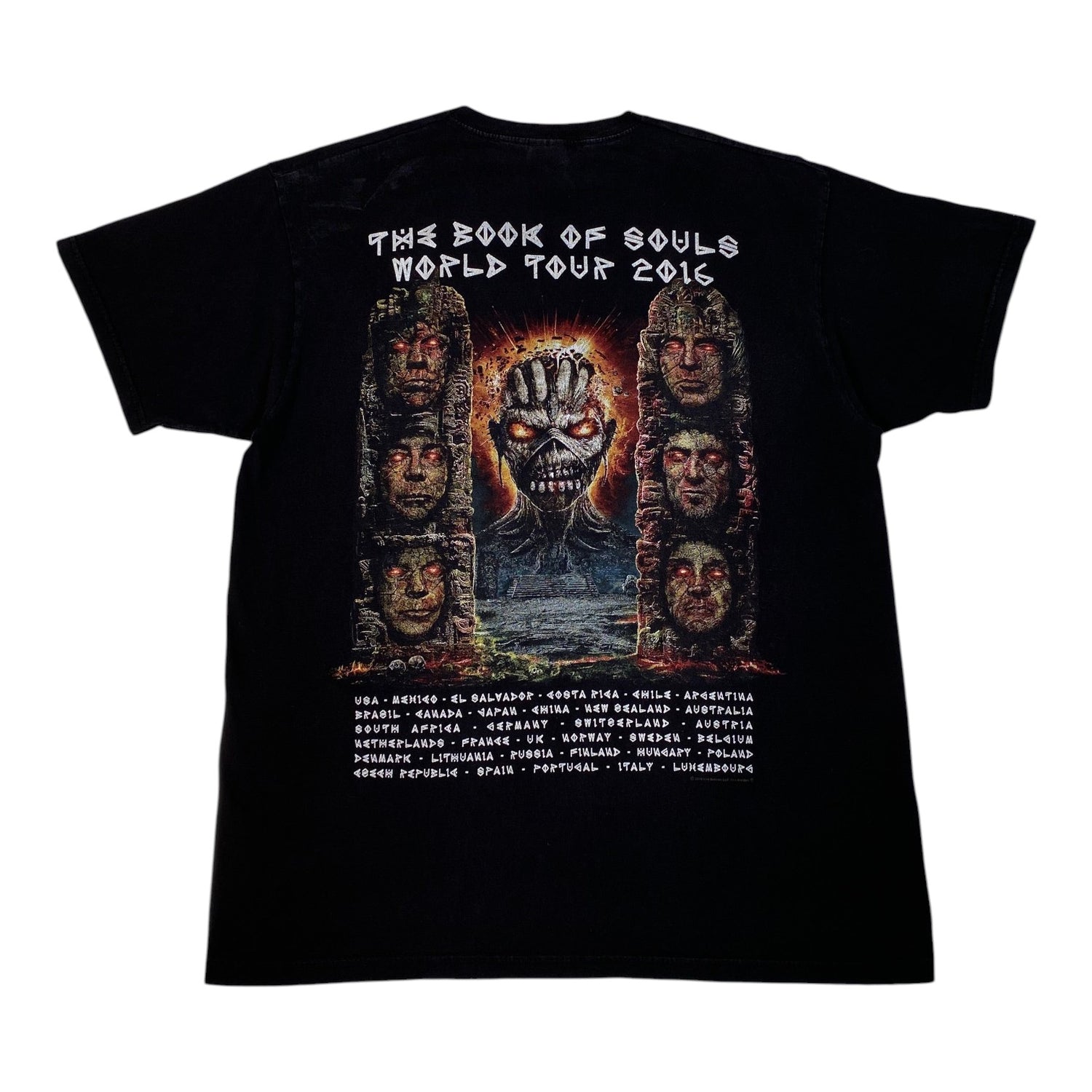 A black short-sleeve graphic T-shirt shown flat against a white background, featuring the back print for Metallica's 'The Book of Souls World Tour 2016' with a large central illustration and a list of tour cities below.