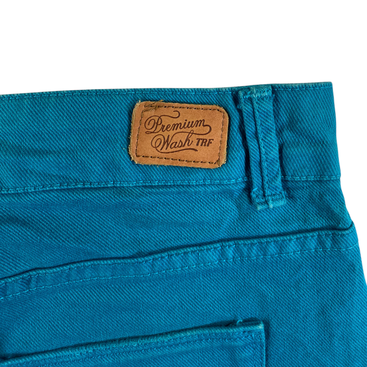 Digg It Thrift & Vintage teal denim mini skirt featuring a brown leather Premium Wash TRF brand patch on the back