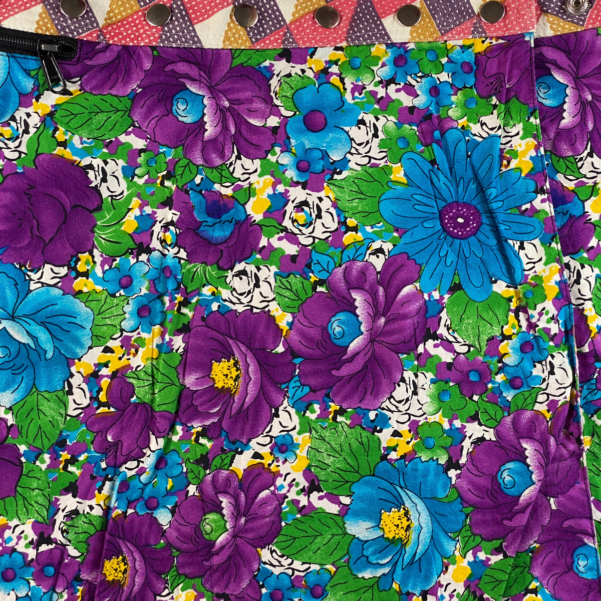 Digg It Thrift & Vintage reversible mini skirt featuring a vibrant floral and butterfly print with snap-wrap closure.