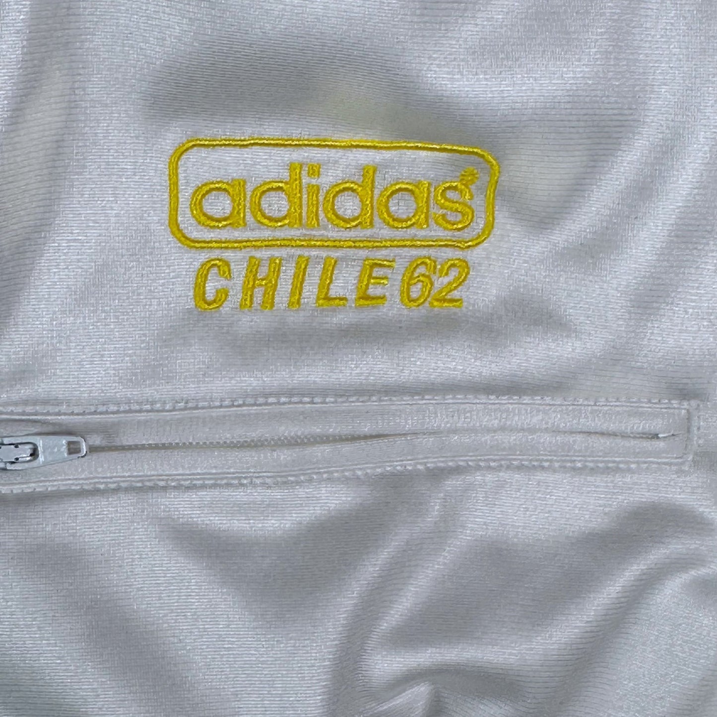 Digg It Thrift & Vintage white Adidas Chile 62 track jacket with yellow embroidered logo and zippered pocket detail.