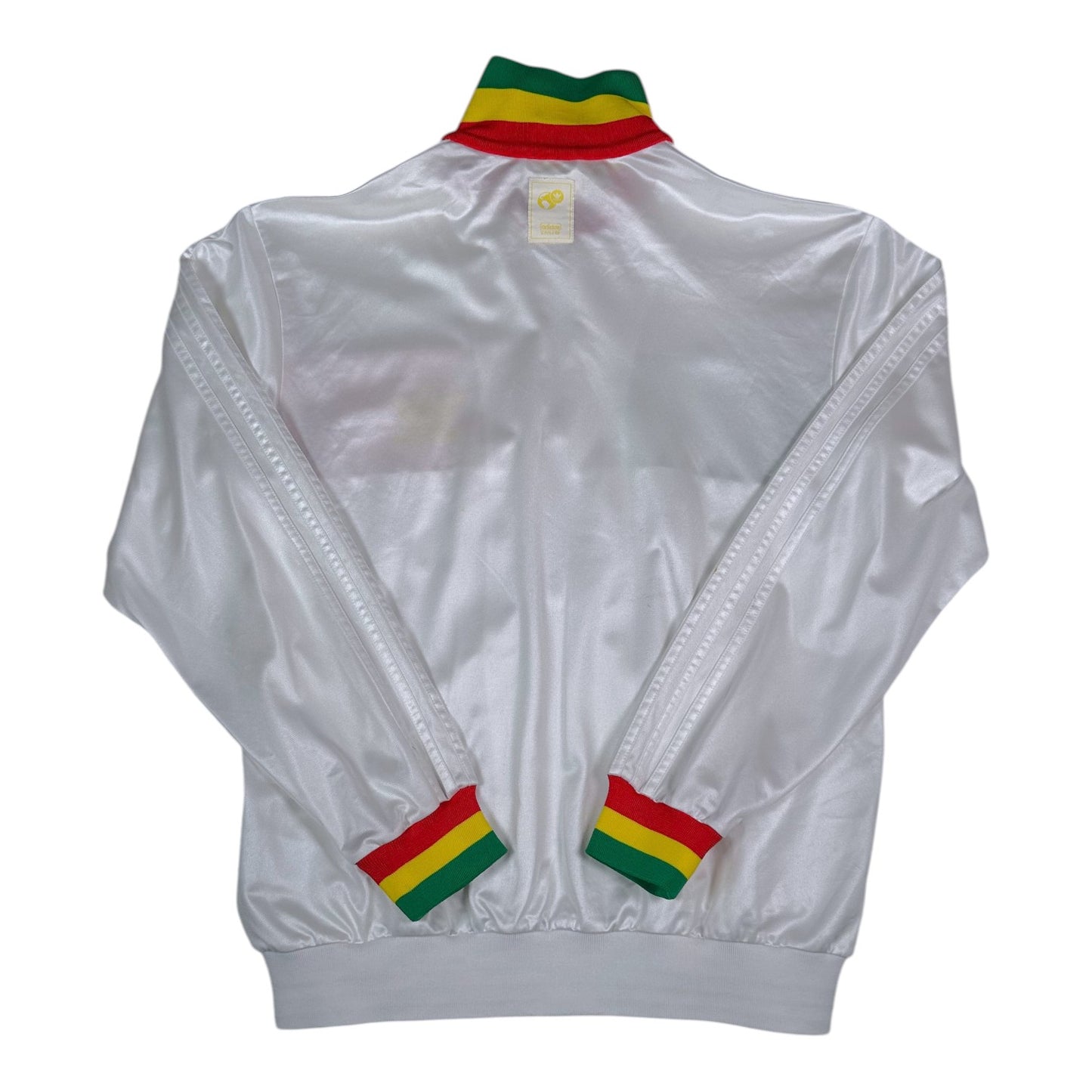 Back view of a white Digg It Thrift & Vintage Adidas Chile track jacket with Rasta-colored collar and cuffs.