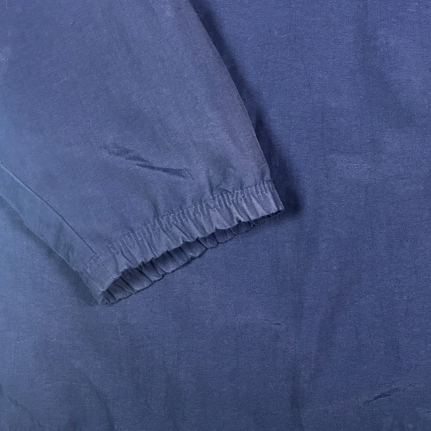 Close-up of navy blue fabric sleeve with elastic cuff from a Digg It Thrift & Vintage Adidas coach jacket