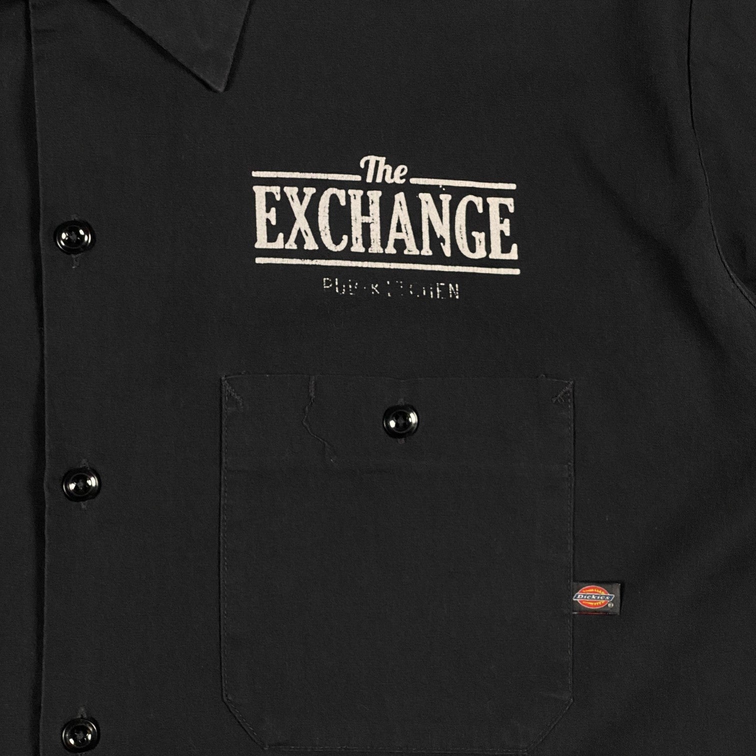 Digg It Thrift & Vintage black Dickies work shirt featuring The Exchange Pub + Kitchen logo and a front chest pocket.