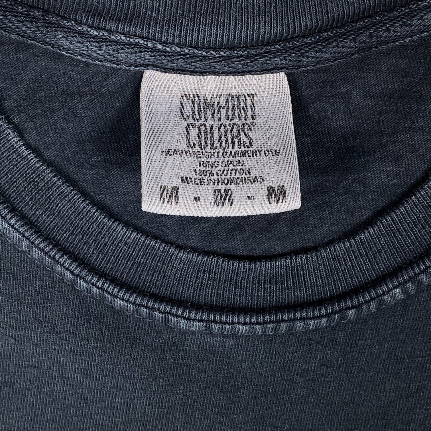Digg It Thrift & Vintage Comfort Colors tag on a black garment-dyed cotton t-shirt, size medium.