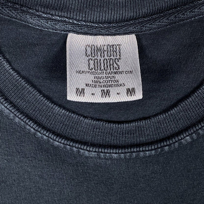 Digg It Thrift & Vintage Comfort Colors tag on a black garment-dyed cotton t-shirt, size medium.