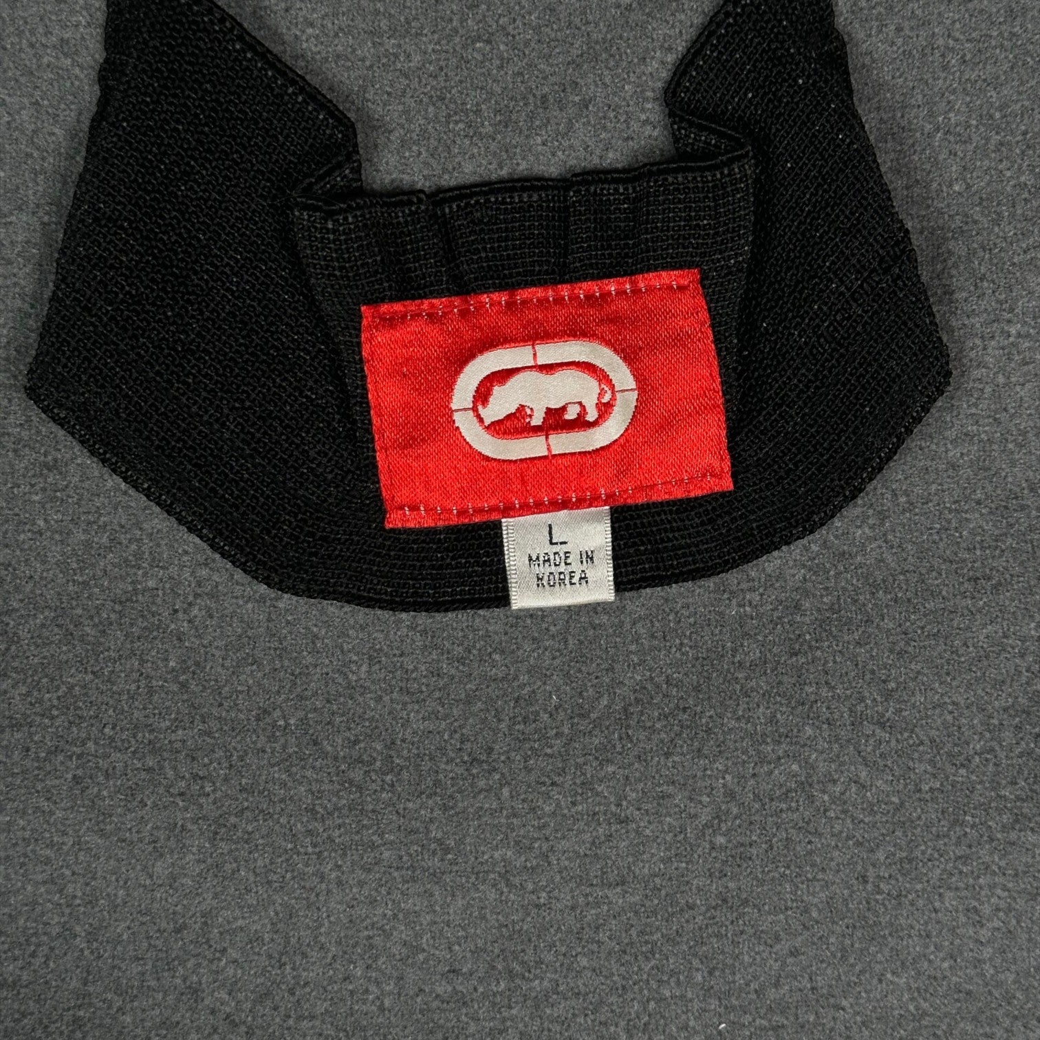 Digg It Thrift & Vintage Ecko Unltd. black fleece jacket neck label with red logo tag and size large label