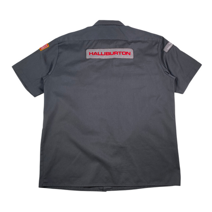 Back view of a gray Digg It Thrift & Vintage Dickies Halliburton work shirt with red logo embroidery and patches.