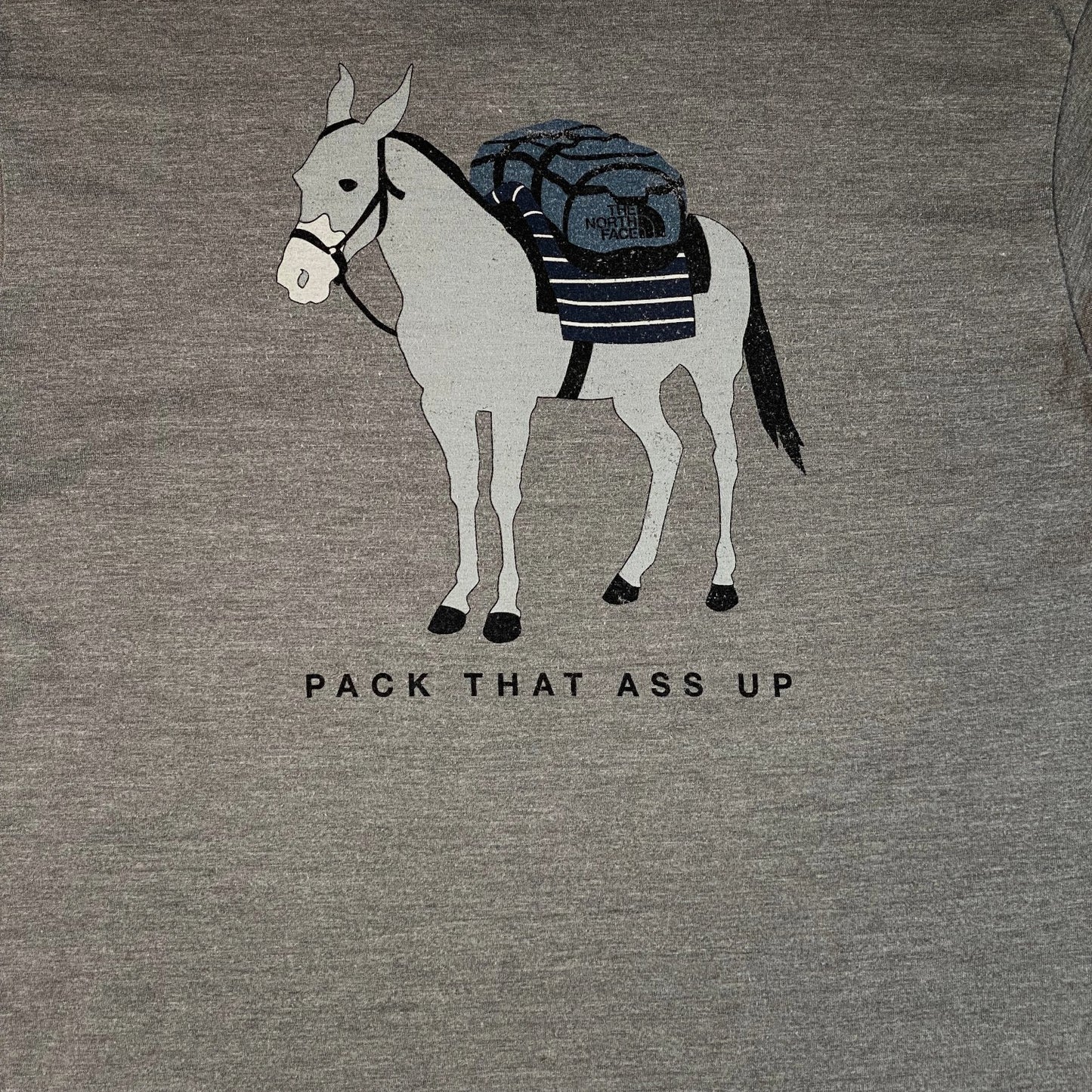 Digg It Thrift & Vintage grey graphic t-shirt featuring a donkey carrying a The North Face backpack and text