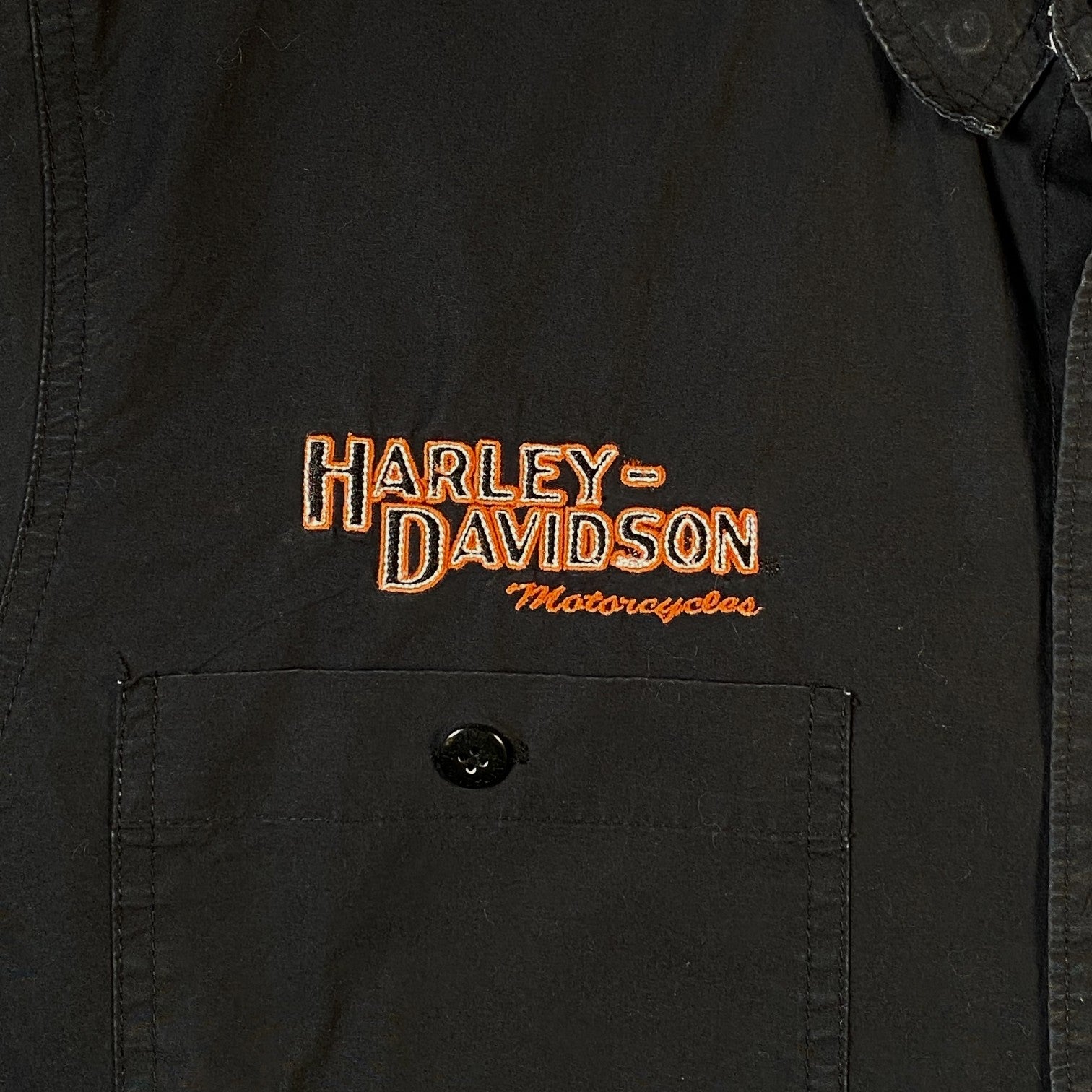Digg It Thrift & Vintage black short-sleeve mechanic shirt featuring orange Harley-Davidson embroidery on the pocket