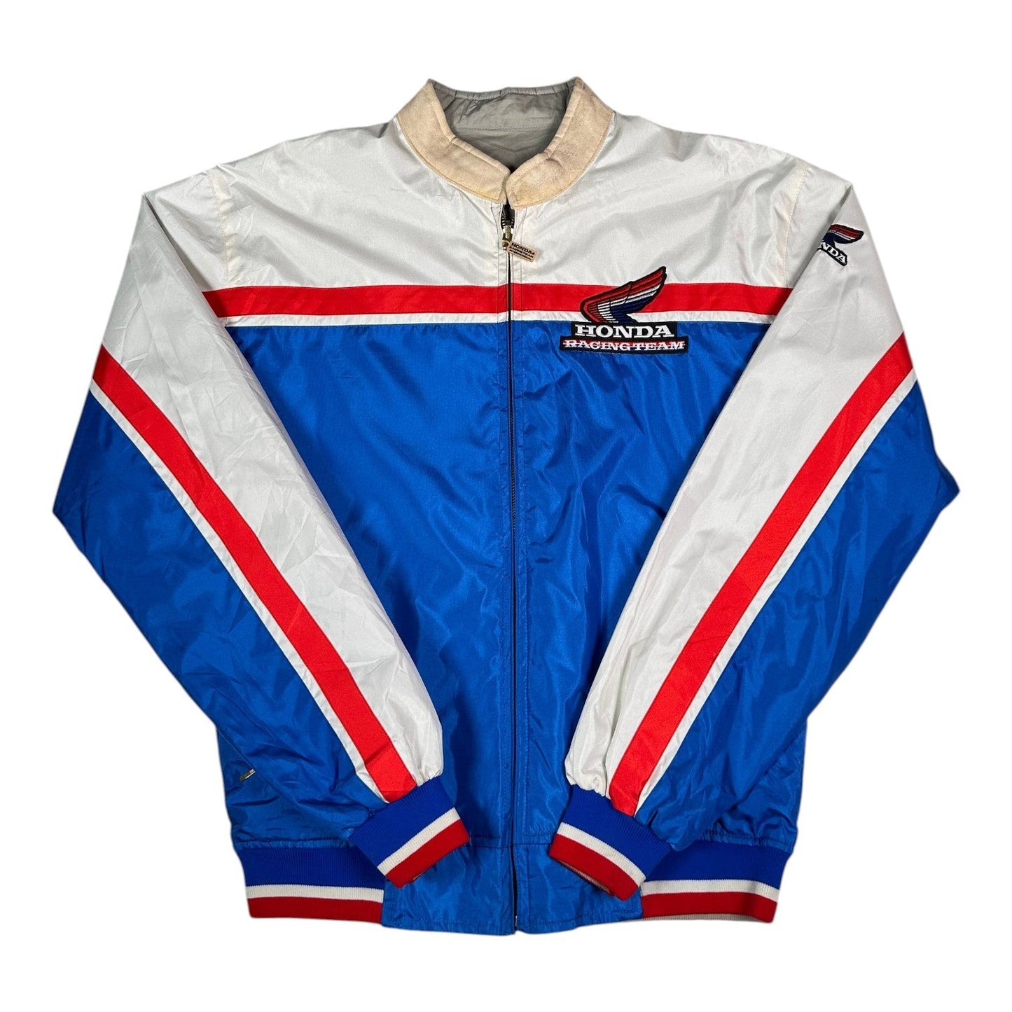 Digg It Thrift & Vintage reversible Honda Racing Team windbreaker jacket in blue, white, and red with striped cuffs.