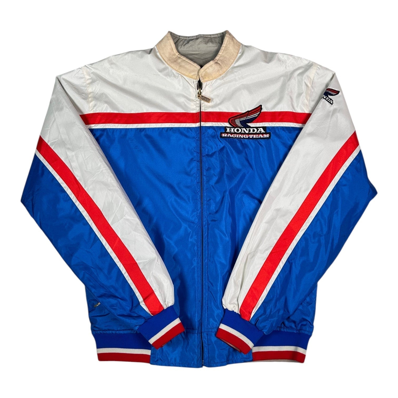 Digg It Thrift & Vintage reversible Honda Racing Team windbreaker jacket in blue, white, and red with striped cuffs.
