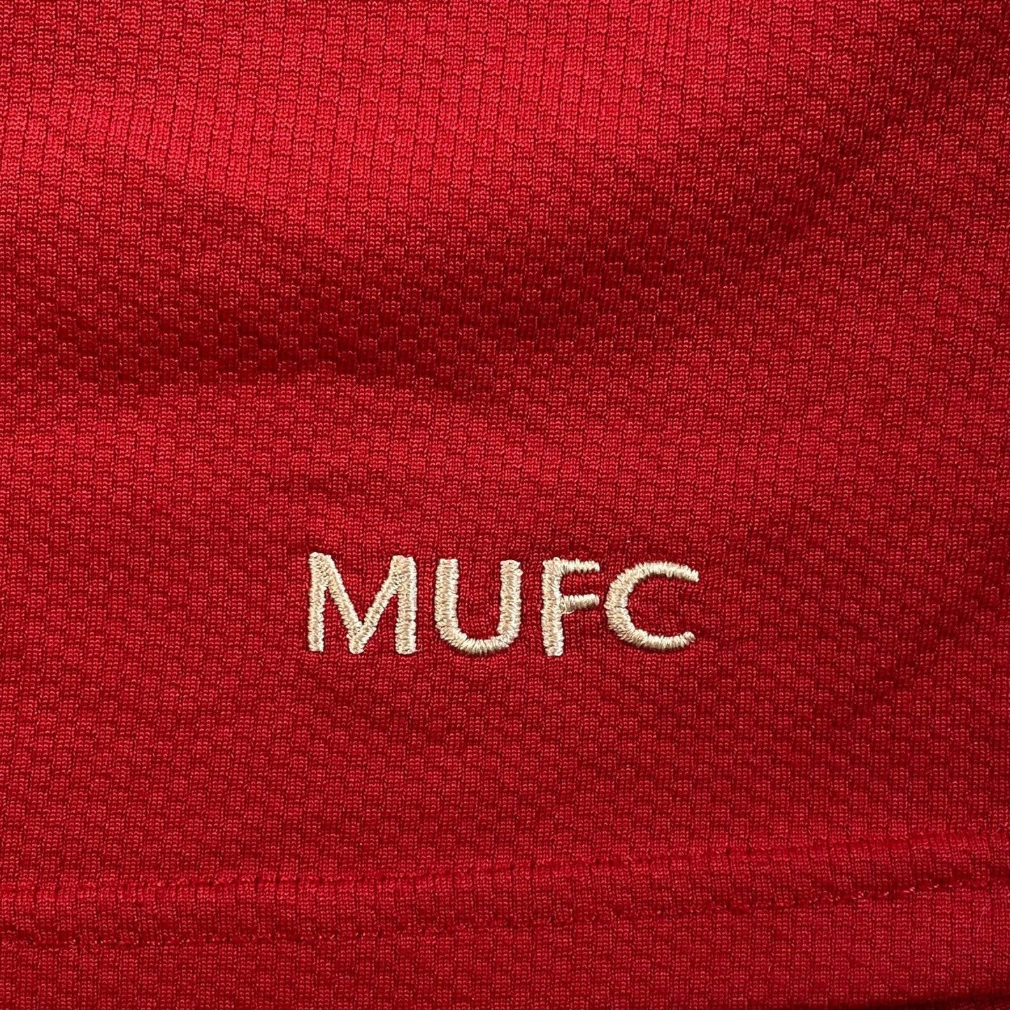 Digg It Thrift & Vintage 2006-2007 Manchester United home shirt detail with embroidered white MUFC logo on red fabric