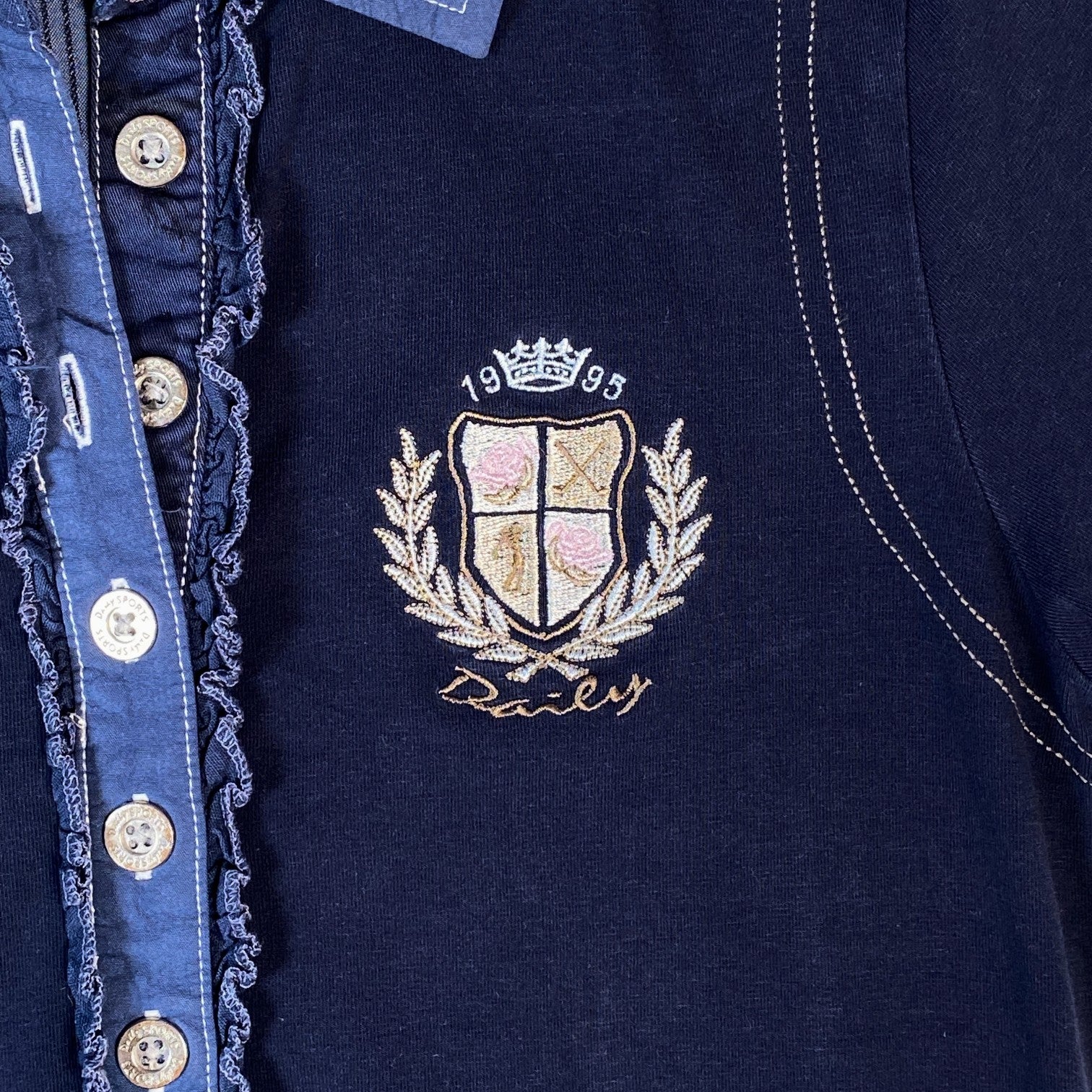 Digg It Thrift & Vintage navy golf polo with ruffle placket, contrast stitching, and 1995 embroidered crest logo.