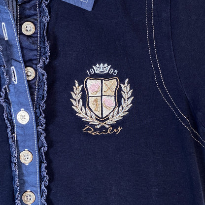 Digg It Thrift & Vintage navy golf polo with ruffle placket, contrast stitching, and 1995 embroidered crest logo.