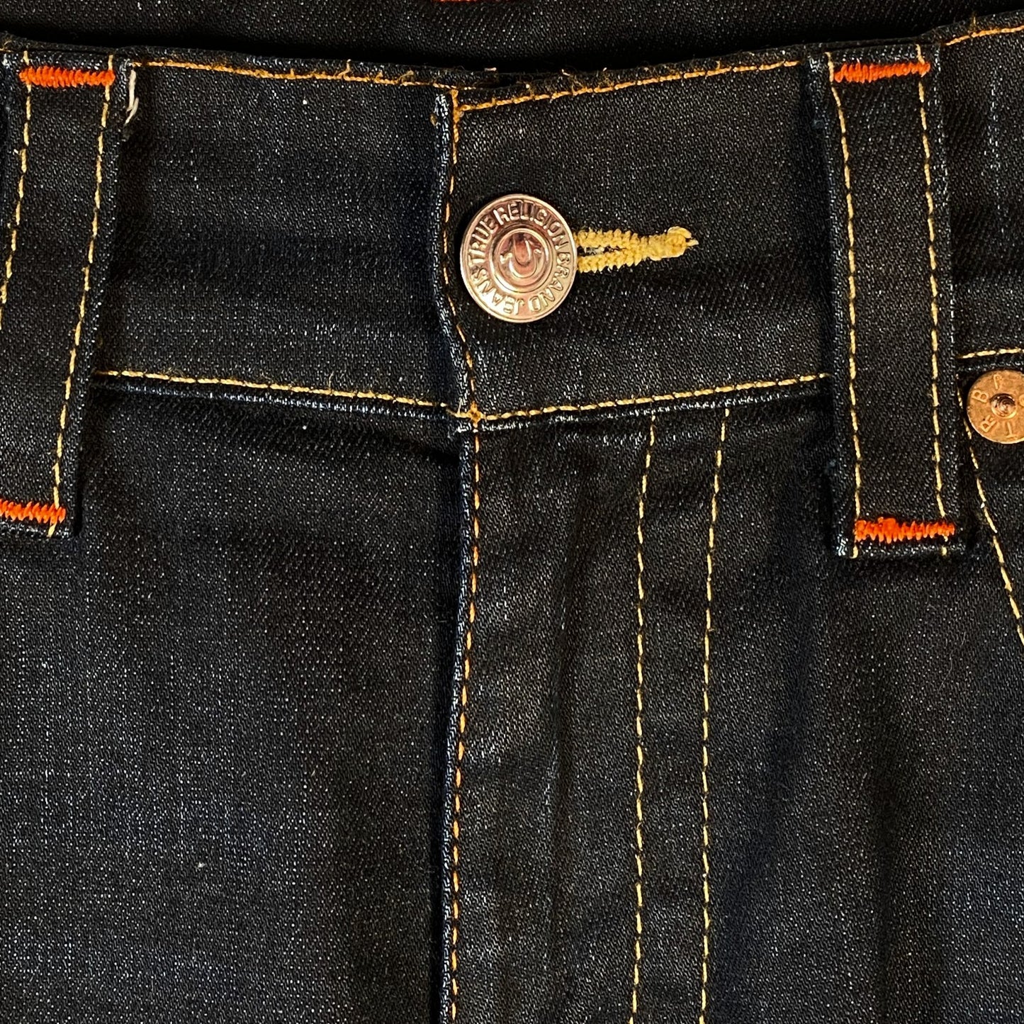 Digg It Thrift & Vintage True Religion dark wash denim jorts featuring signature orange contrast stitching and button